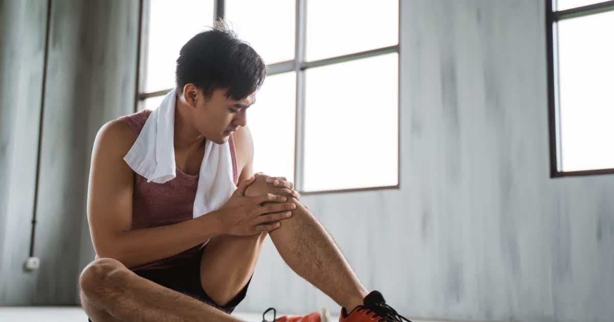 A man rests after injuring his knee