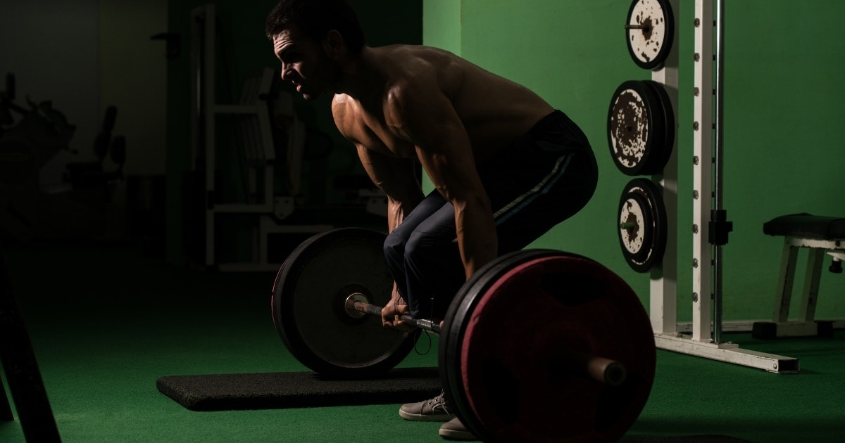 A man experiences back pain during a deadlift
