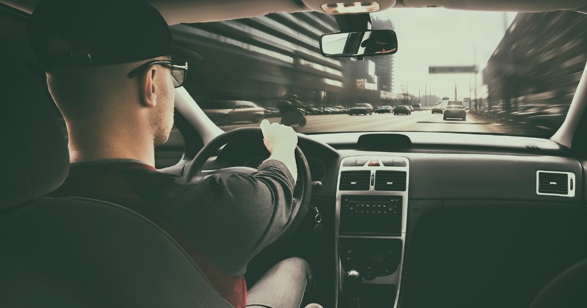 A man drives in traffic to the gym