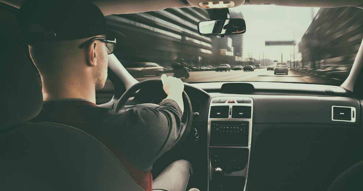A man drives in traffic to the gym
