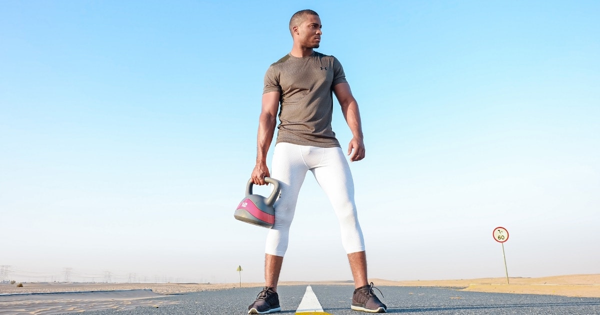 A man holding a digital kettlebell in the street
