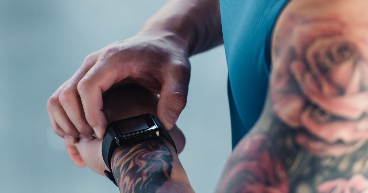 A man looking at his watch during workout