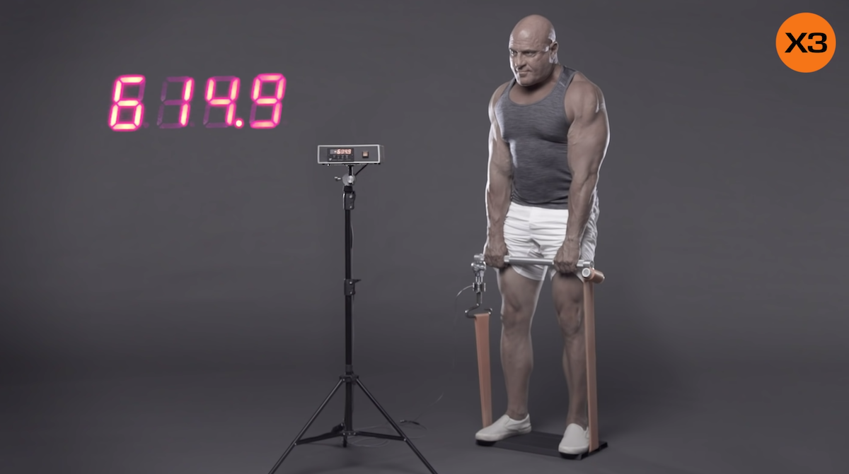 A man performs a heavy deadlift with variable resistance