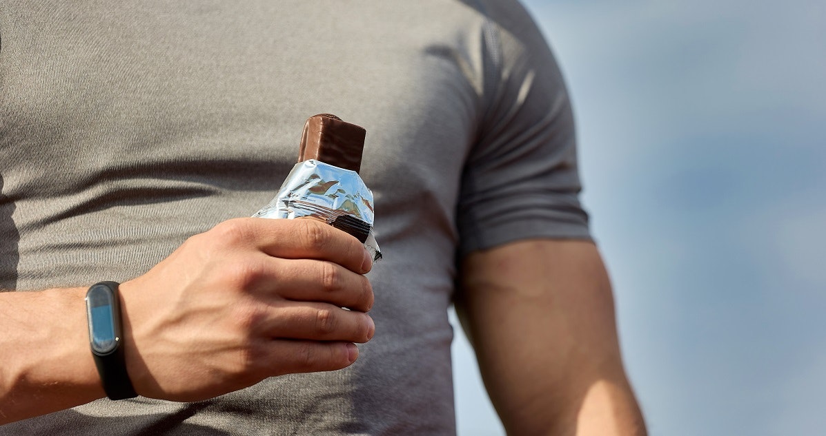 an athlete eats a protein bar