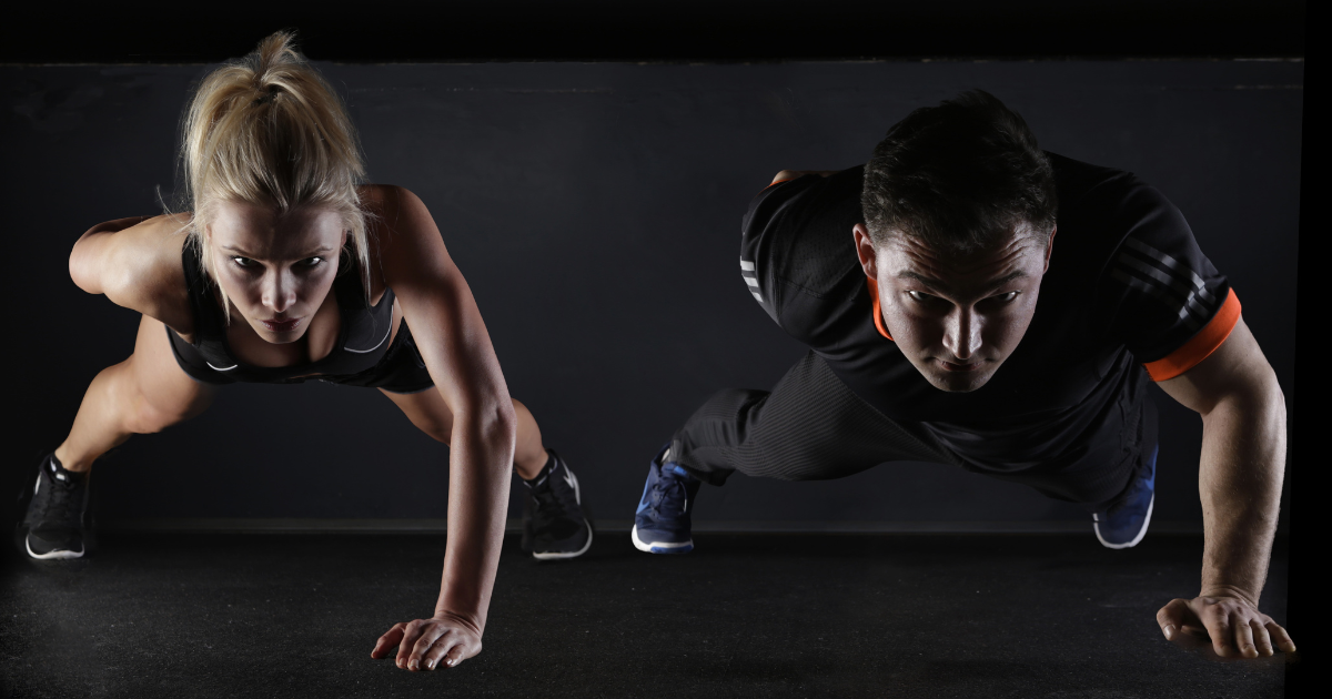 Woman and man doing one handed pushups