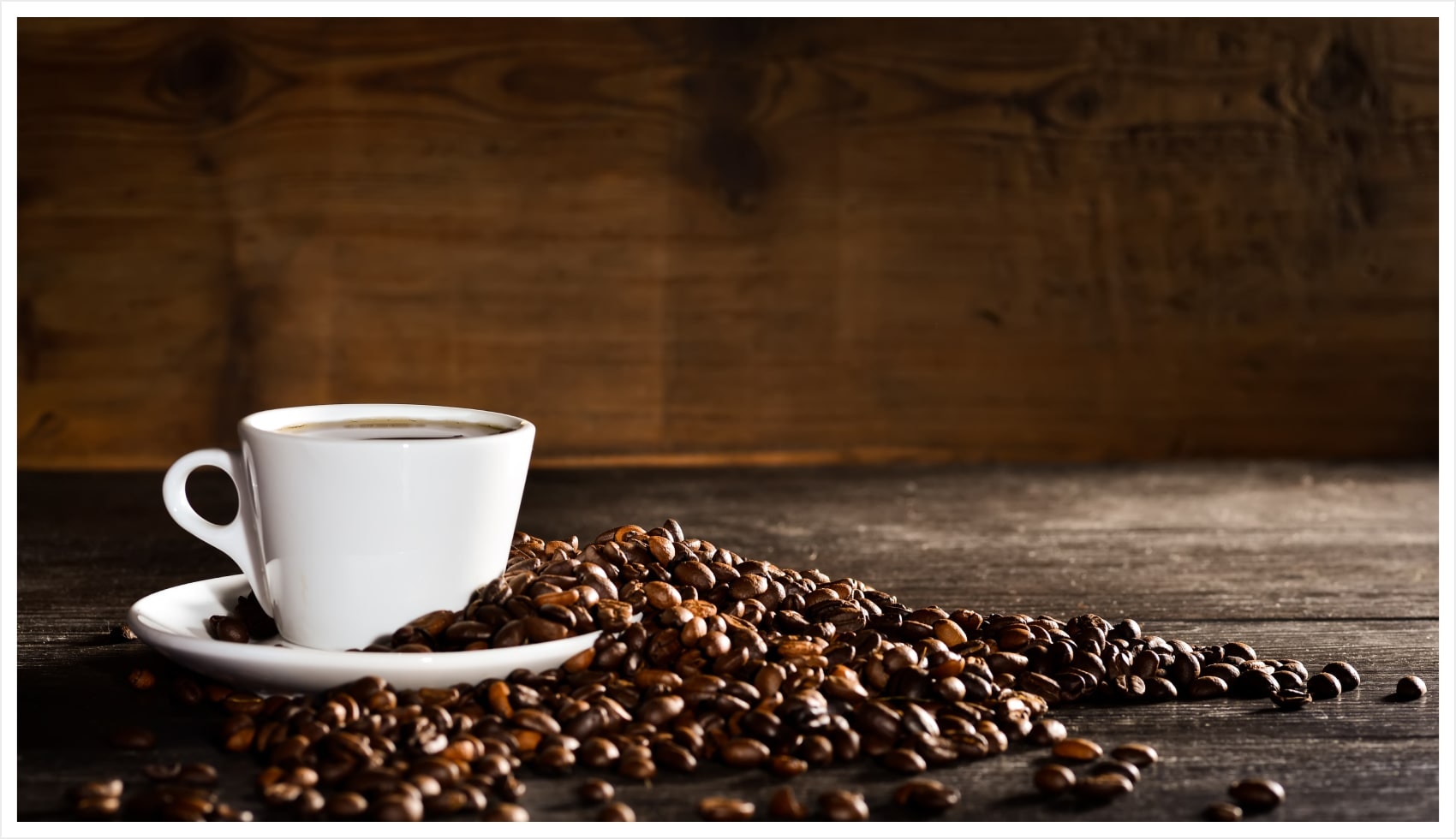 Espresso cup with coffee beans on a wood table