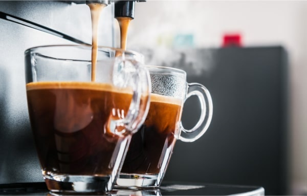 Espresso cups being filled by an espresso machine