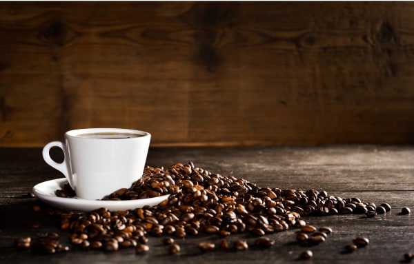 Espresso cup with coffee beans on a wood table