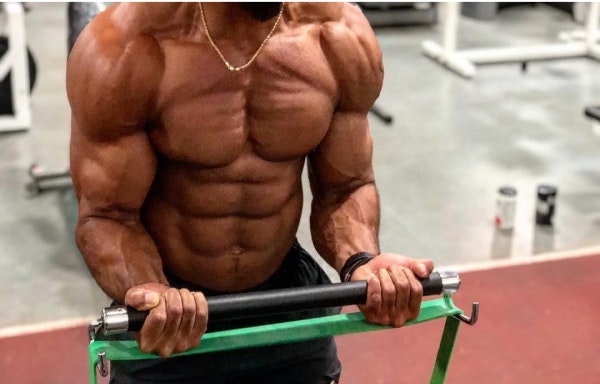 Man doing bicep curls with resistance band and bar