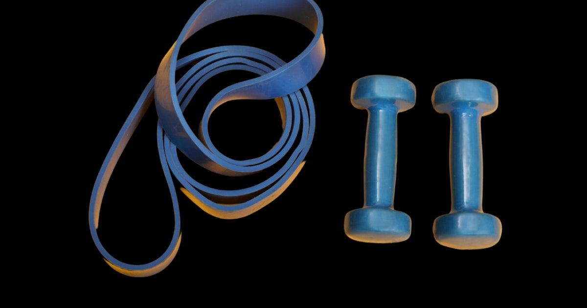 2 dumbbells sit next to a resistance band